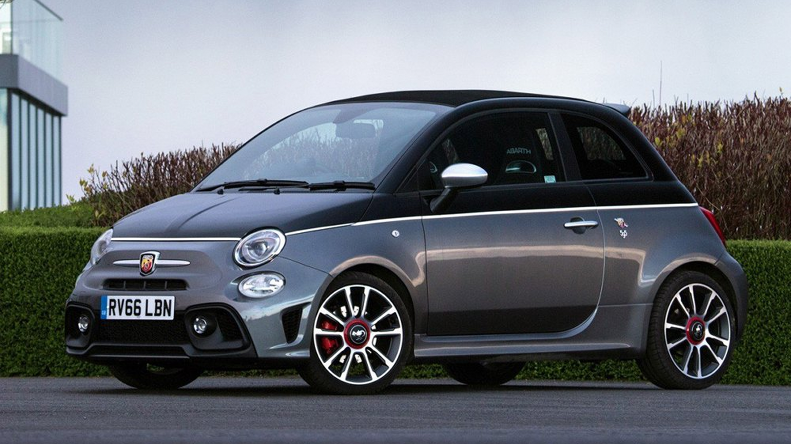 Abarth 595C Cabrio blanco, vista lateral con techo descapotado.