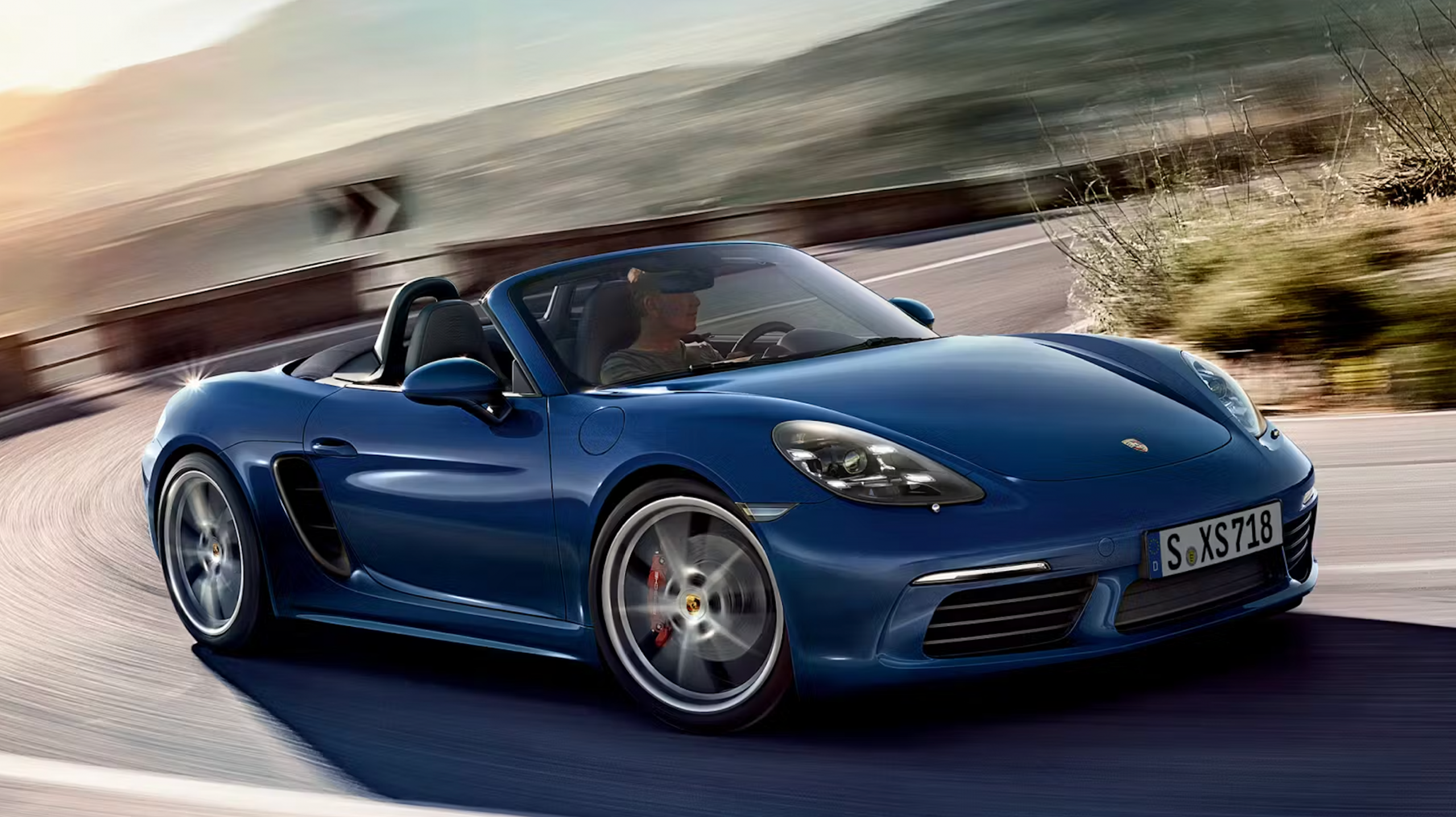 Porsche 718 Boxster S descapotable en color azul, conducción deportiva.