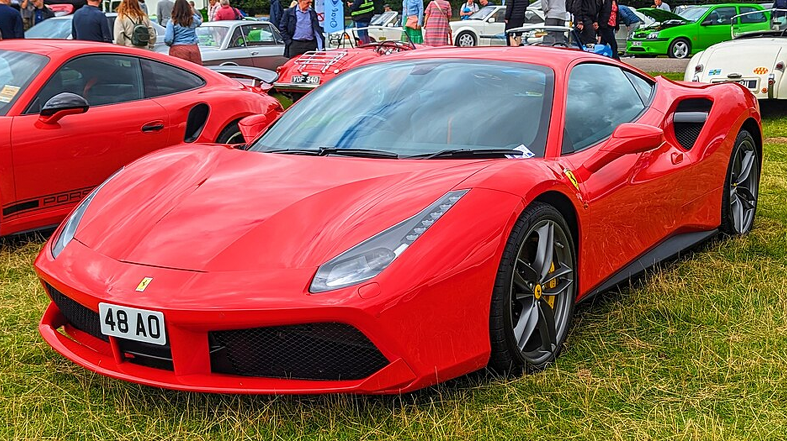 Ferrari 488 GTB rojo deportivo aparcado sobre césped.