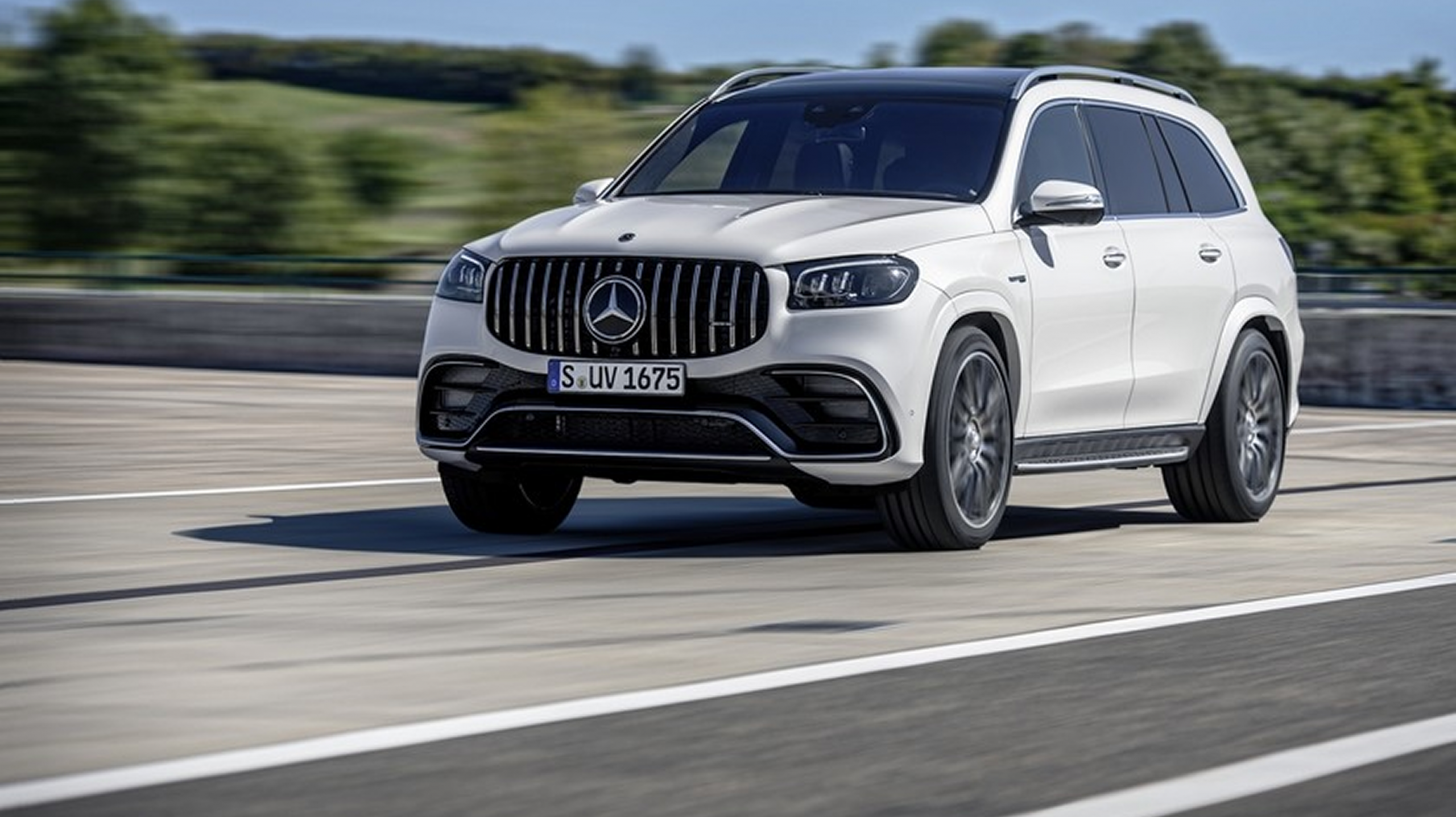 Mercedes GLS 63 AMG blanco en carretera a alta velocidad.
