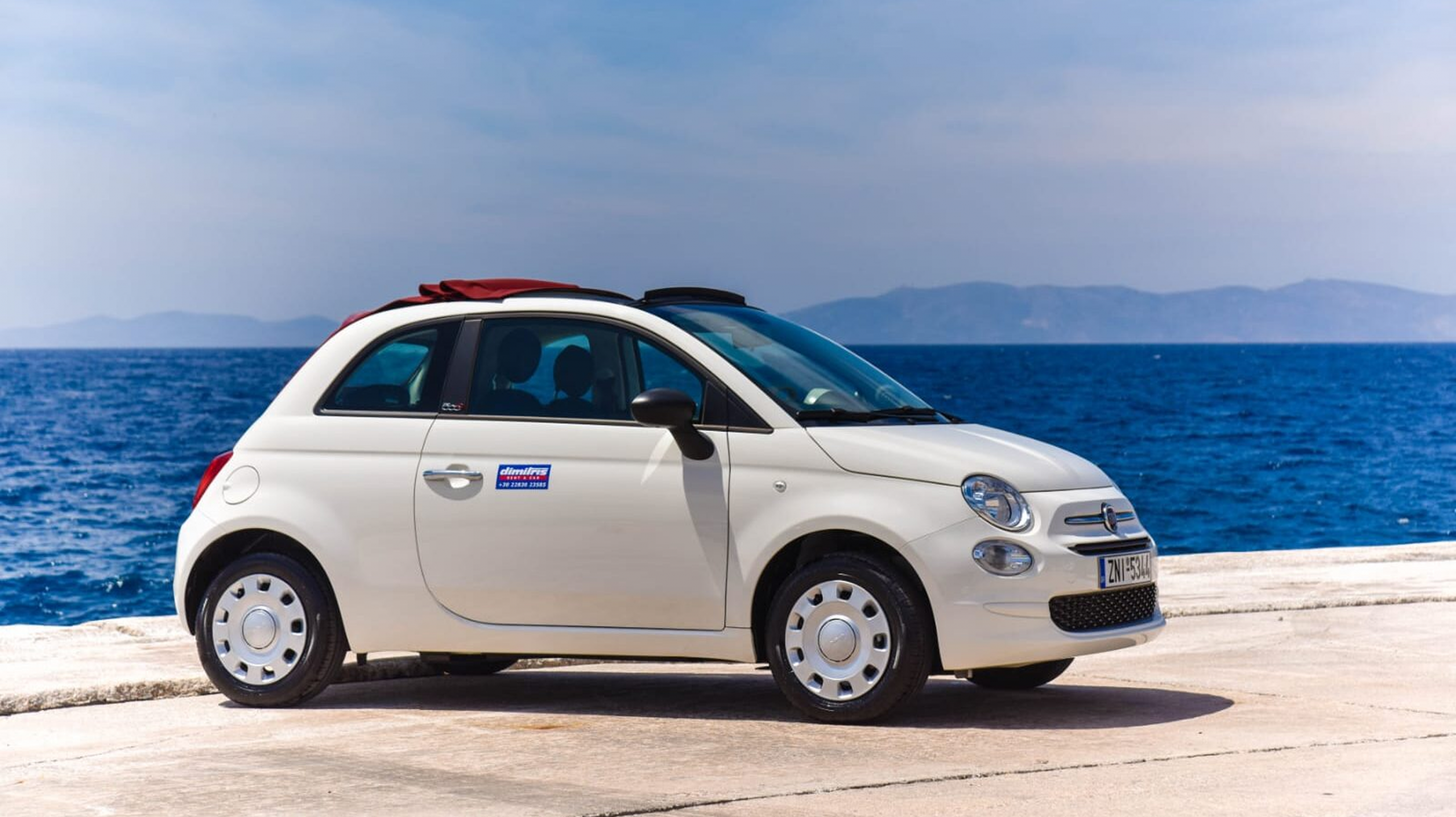 Fiat 500 Cabrio blanco junto al mar en Ibiza