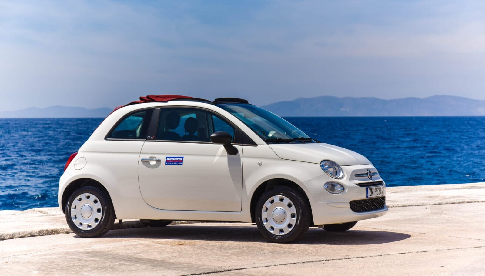 Fiat 500 Cabrio blanco junto al mar en Ibiza